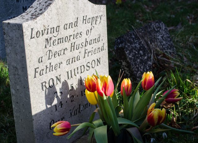 An upright stone headstone in a churchyard